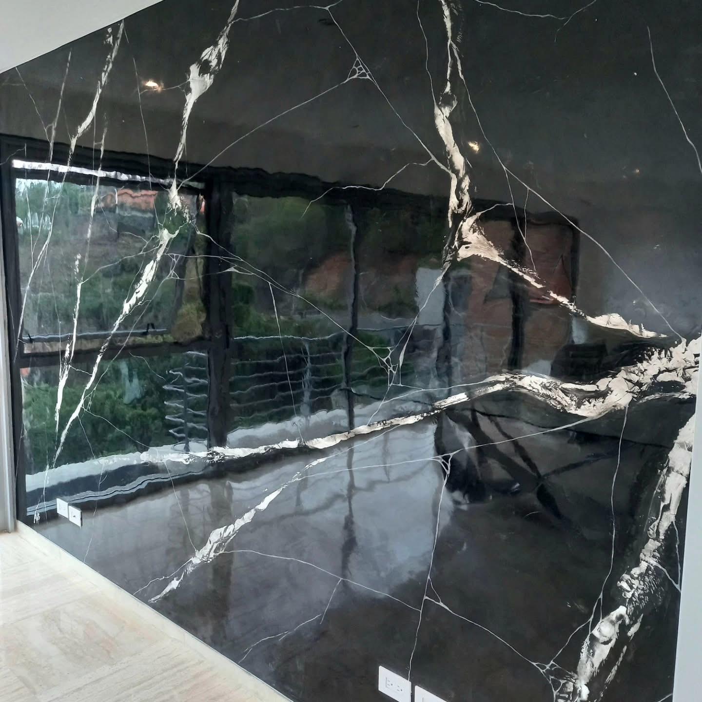 Black marble-look wall with white and gold veining